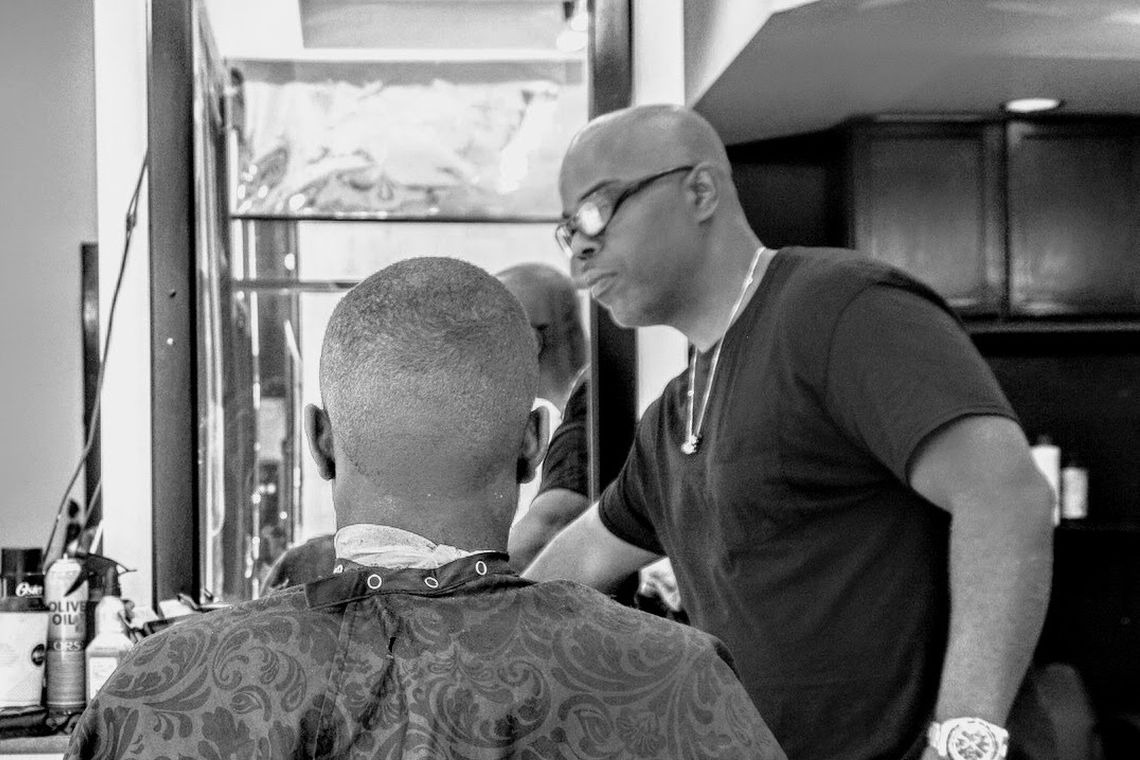 Hanif Akins, Nisusthebarberman, cutting a client's hair in his Colorado Springs shop